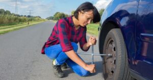 woman changing flat tire