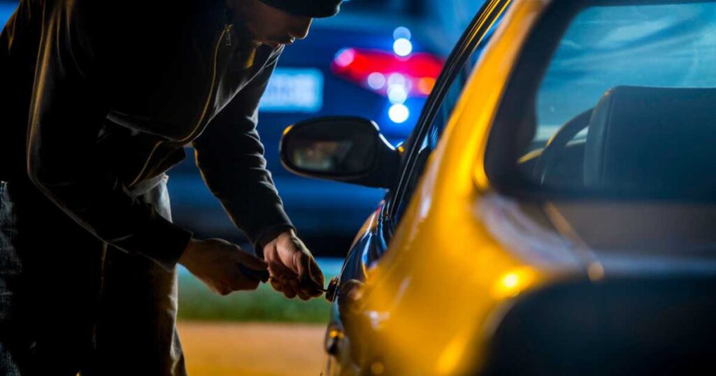 Car Thief Using a Screwdriver to Break into a Car stock photo