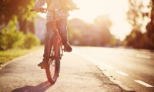 child riding a bicycle on sidewalk