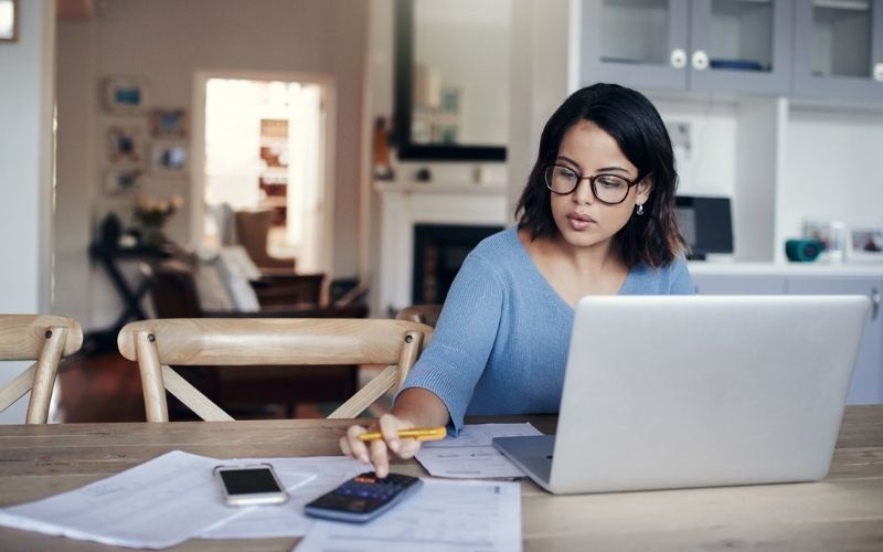 woman using calculator and computer