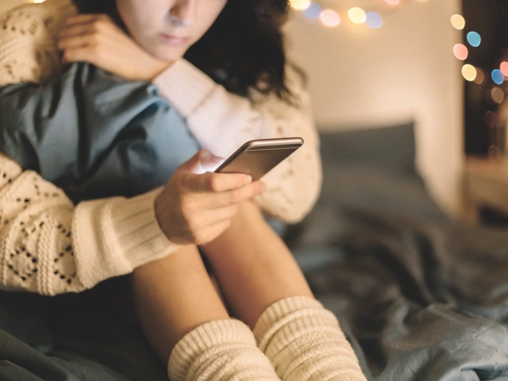 girl texting in bedroom