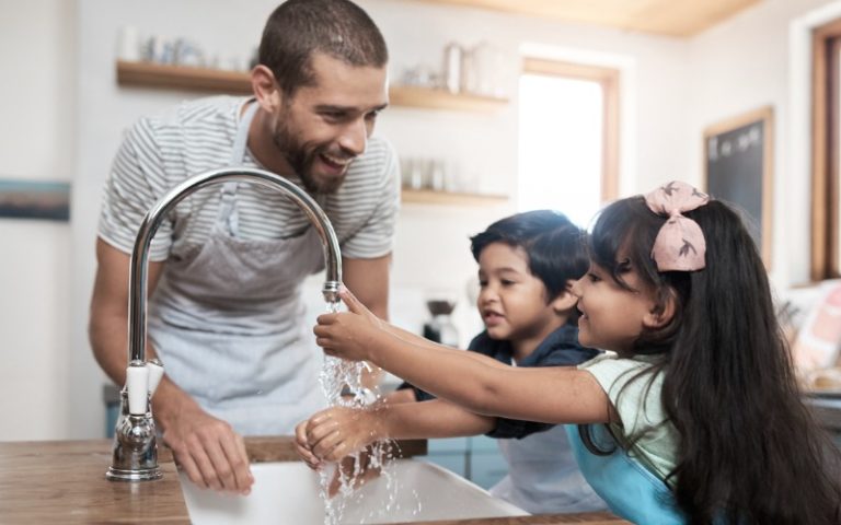 sister and brother washing hands with dad