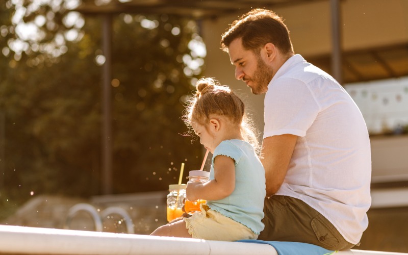 father and daughter drinking juice