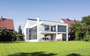 green home on summer meadow