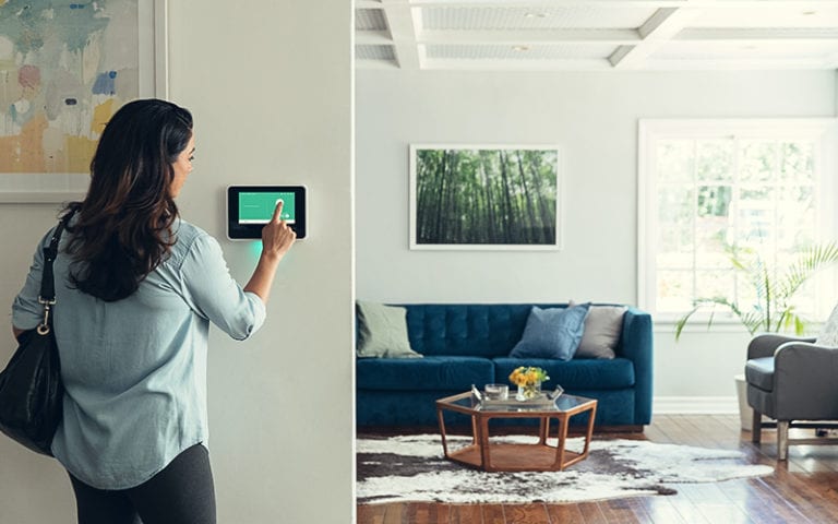 woman interacting with sky security panel in house