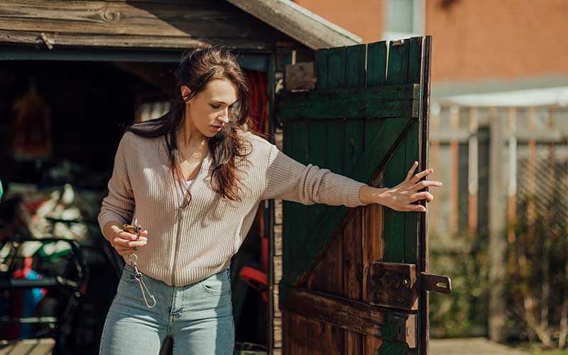 Woman locking outdoor shed