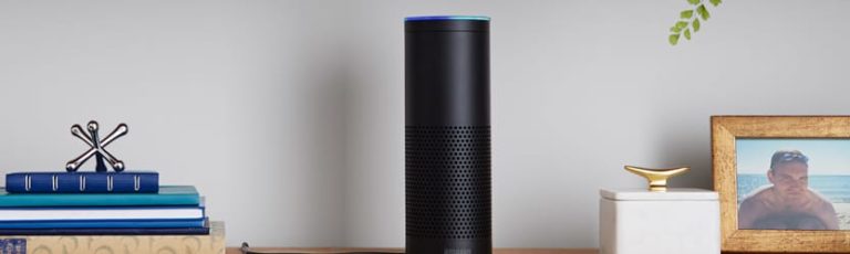 Amazon Echo on shelf with books, photos