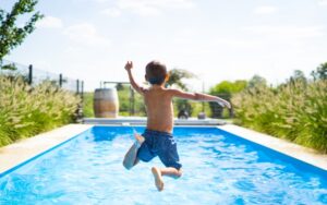 boy jumping into a pool