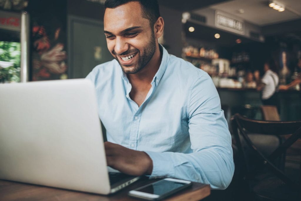 Man working on laptop in cafe