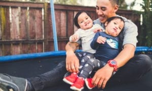 a parent with his children sitting on a trampoline