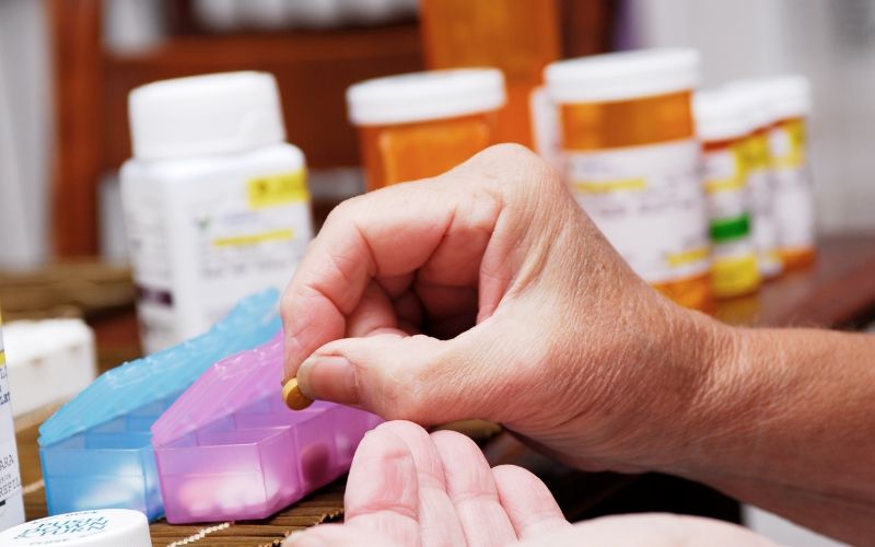 Senior woman organizing pill box