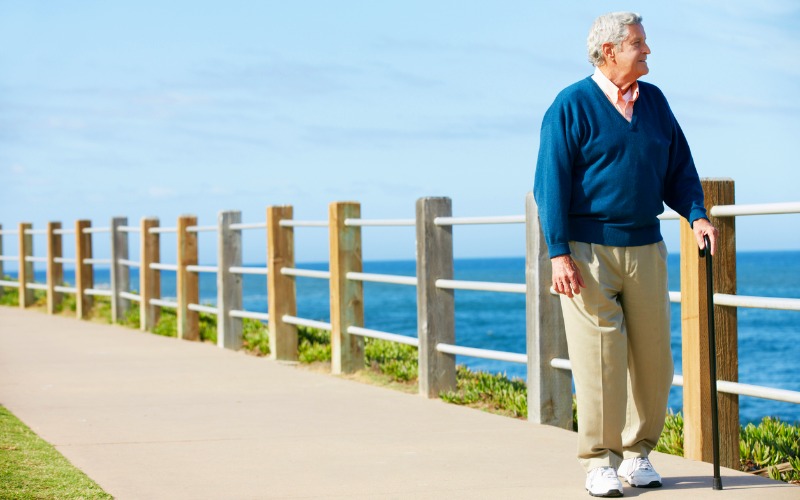 senior man walking by the ocean