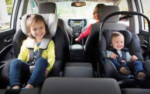 two smiling children in car seats