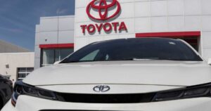 White Toyota corolla close-up in front of a red dealer Toyota sigh