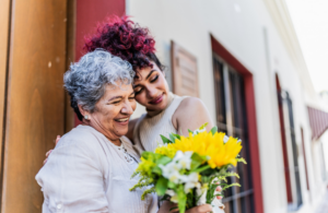 Adult daughter giving mother flowers